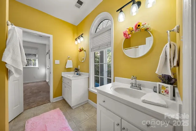 a bathroom with a sink mirror and tub
