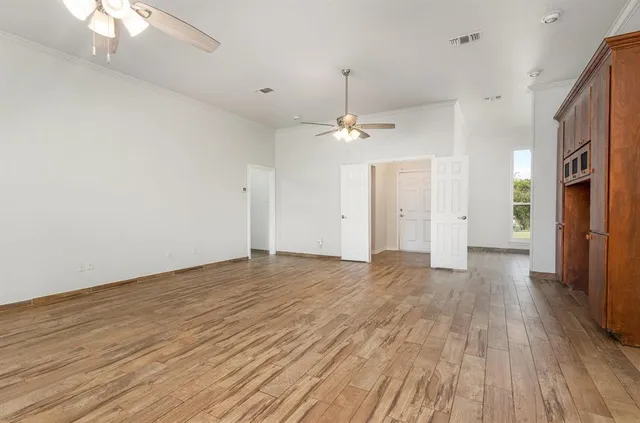 a view of an empty room with wooden floor