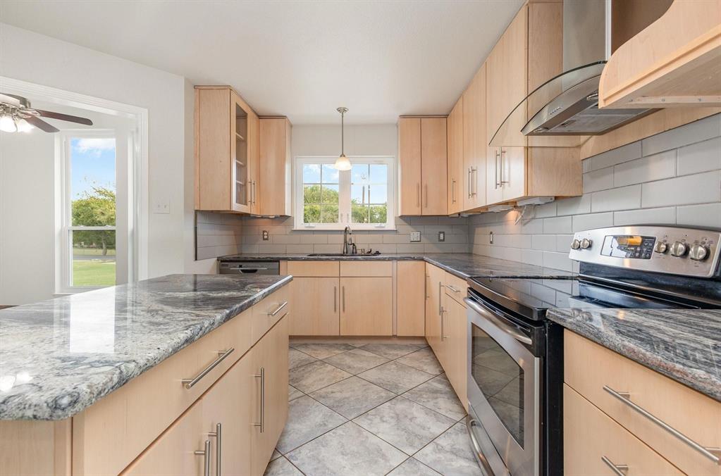 3961 Joe Wilson Road Midlothian, TX 76065 - Photo 3 of 27 a kitchen with granite countertop a sink a stove and cabinets