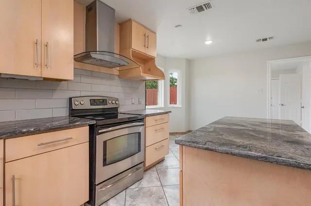 a kitchen with granite countertop cabinets stainless steel appliances and sink