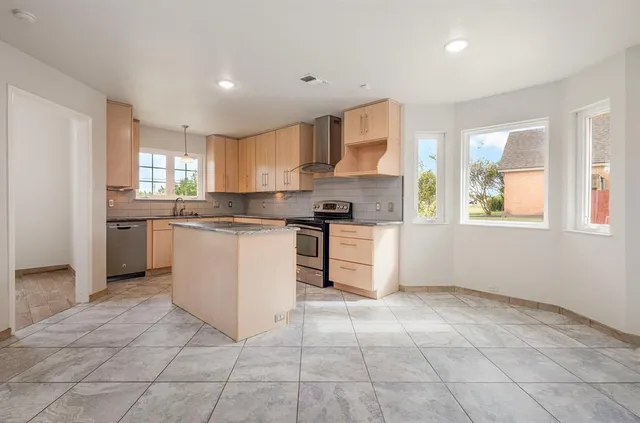 a kitchen with stainless steel appliances granite countertop a stove sink and cabinets