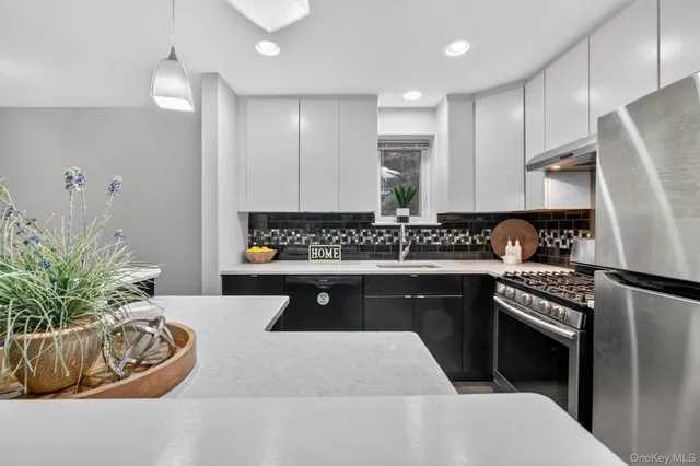 a kitchen with stainless steel appliances granite countertop a sink a stove a refrigerator cabinets and living room view