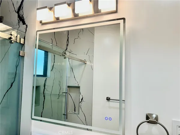 a bathroom with a sink and mirror with bathtub