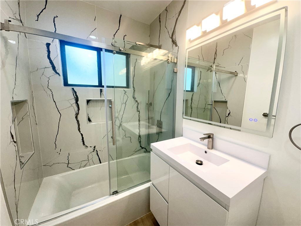 301 Ashland Avenue, Unit 2 Santa Monica, CA 90405 - Photo 16 of 24 a bathroom with a sink and mirror with bathtub