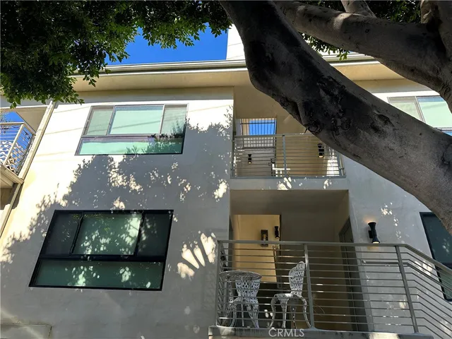 a view of a building with a window and potted plants