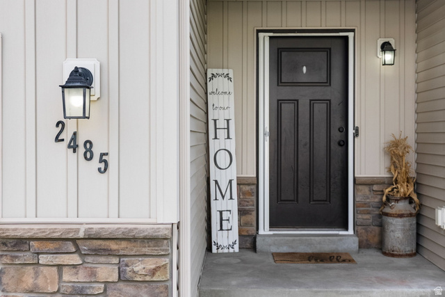 2485 South 1100th Street West Logan, UT 84321 - Photo 8 of 53 Cream-colored vertical siding exterior with a black panel-style entry door