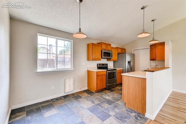 1875 Doherty Road Colorado Springs, CO 80916 - Photo 3 of 11 SS appliances, slate tile flooring entry to and from garage.