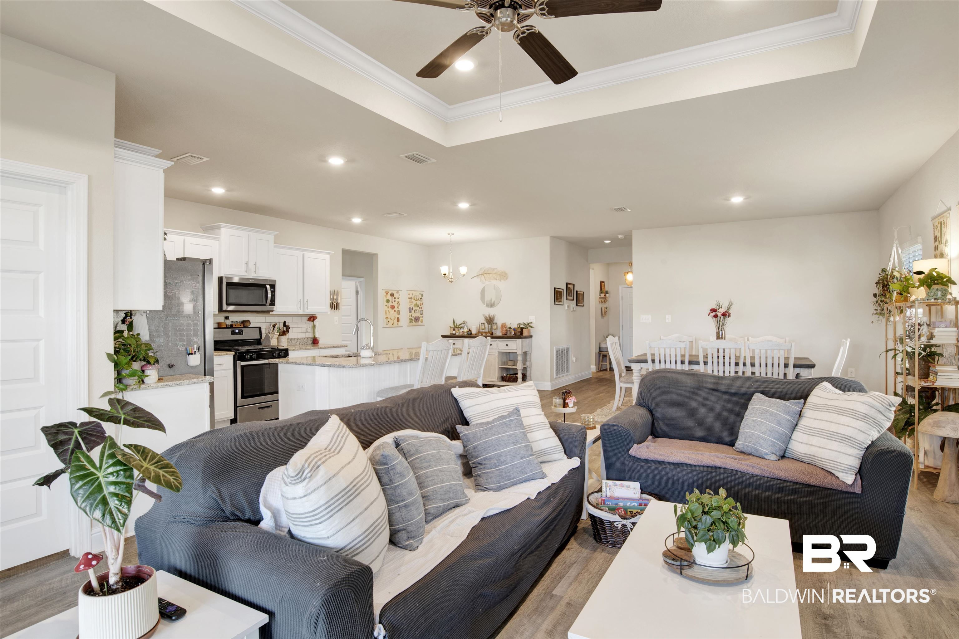 9622 Volterra Avenue Daphne, AL 36526 - Photo 10 of 31 Living room with a raised ceiling, crown molding, light hardwood / wood-style flooring, and ceiling fan with notable chandelier