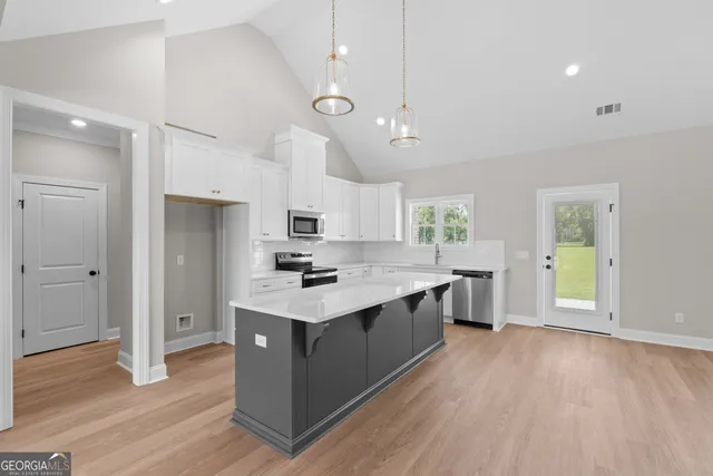 a kitchen with stainless steel appliances a sink stove and wooden floor
