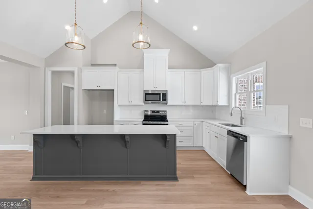 a kitchen with stainless steel appliances granite countertop a sink a stove and a refrigerator