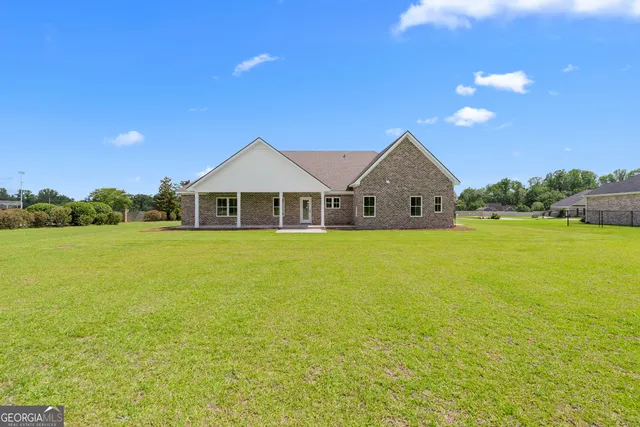 a front view of a house with a garden and yard