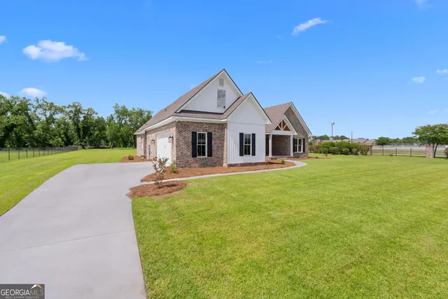 a front view of a house with yard patio and green space