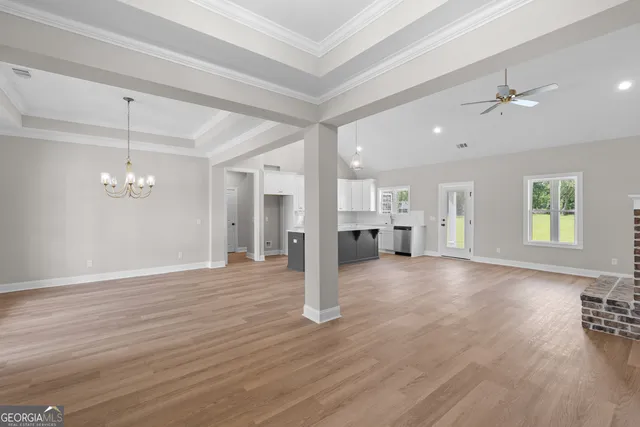 a view of empty room with wooden floor and window