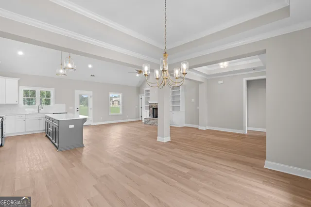 a view of a livingroom with a chandelier furniture and a ceiling fan