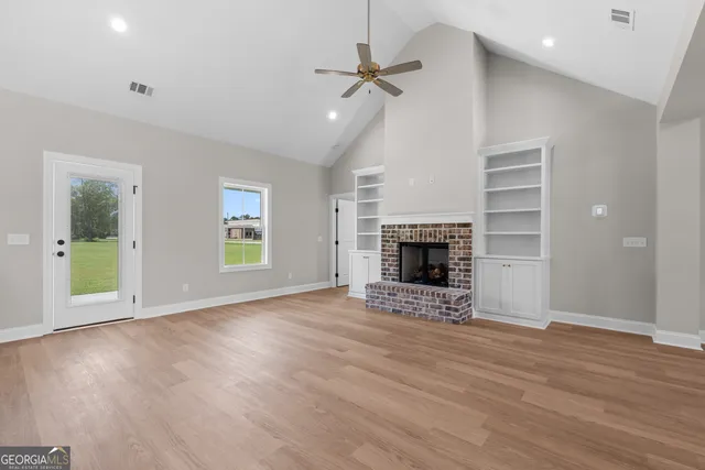an empty room with windows and a fireplace