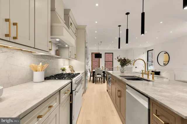 a kitchen with stainless steel appliances granite countertop a sink a stove and a wooden floors