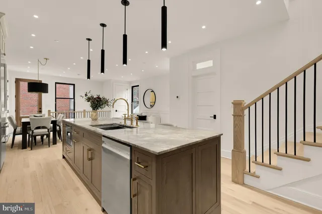 a kitchen with stainless steel appliances granite countertop a sink a stove and a wooden floors