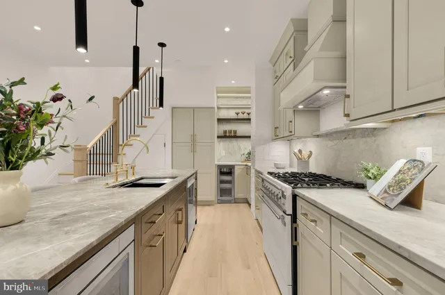 a kitchen with stainless steel appliances granite countertop a stove and a white cabinets