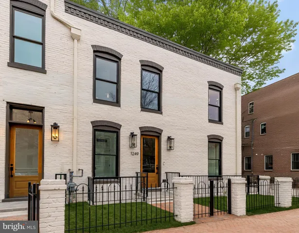a living room with furniture kitchen view and a large window