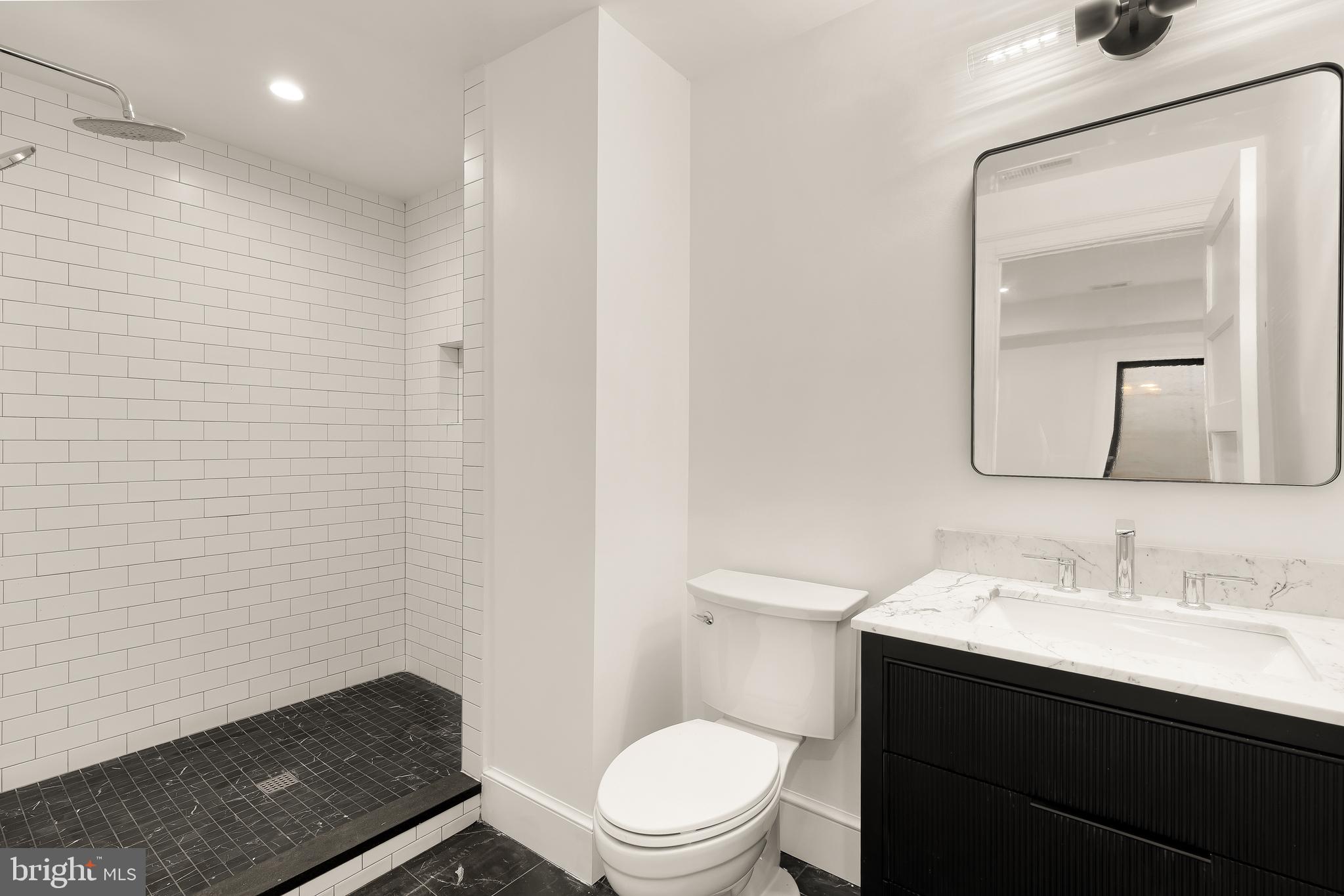 1249 4th Street Northwest Washington, DC 20001 - Photo 29 of 32 a bathroom with a sink a toilet a mirror and vanity