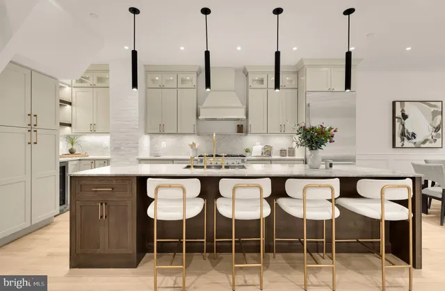 a kitchen with stainless steel appliances granite countertop a sink a stove a refrigerator and white cabinets