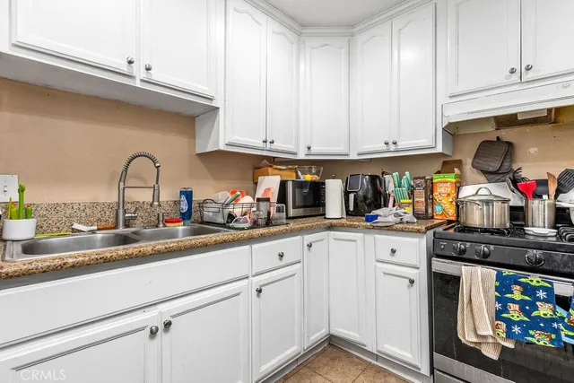 a kitchen with granite countertop a sink stainless steel appliances and cabinets