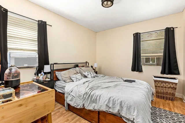 a bedroom with a bed and a flat tv screen next to a window