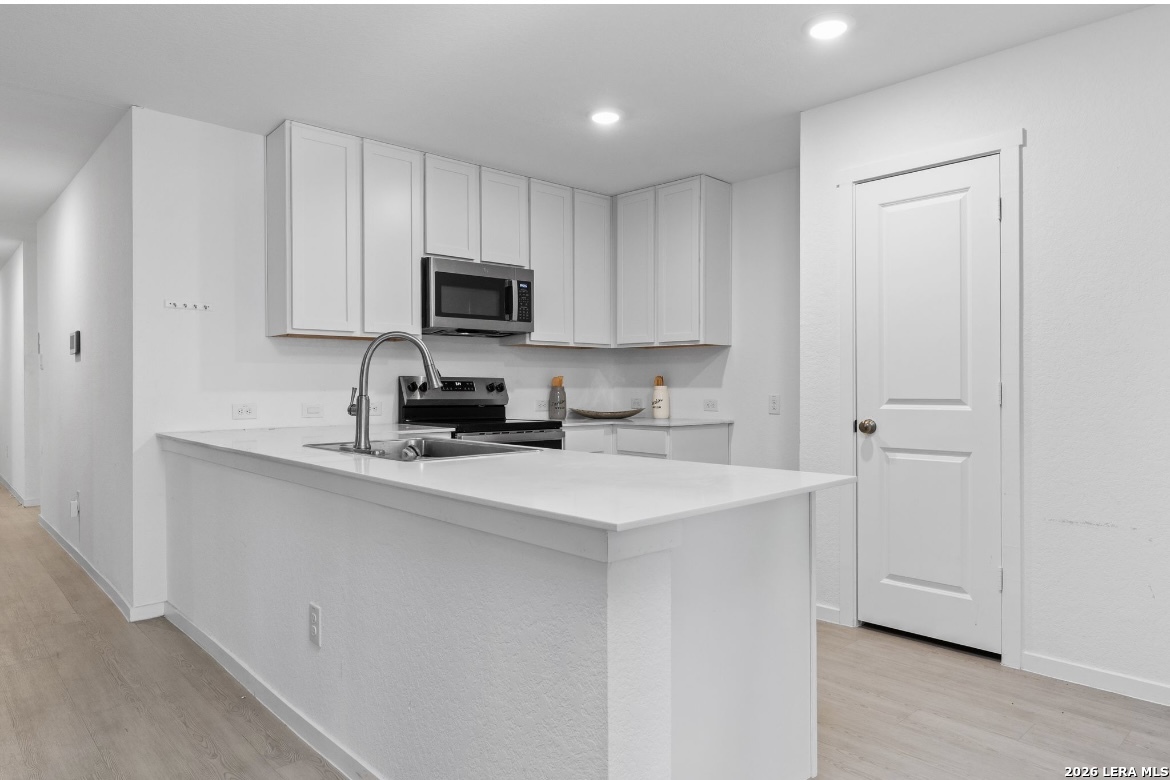 3849 High Tide Seguin, TX 78155 - Photo 8 of 15 a kitchen with a sink a stove a microwave and cabinets