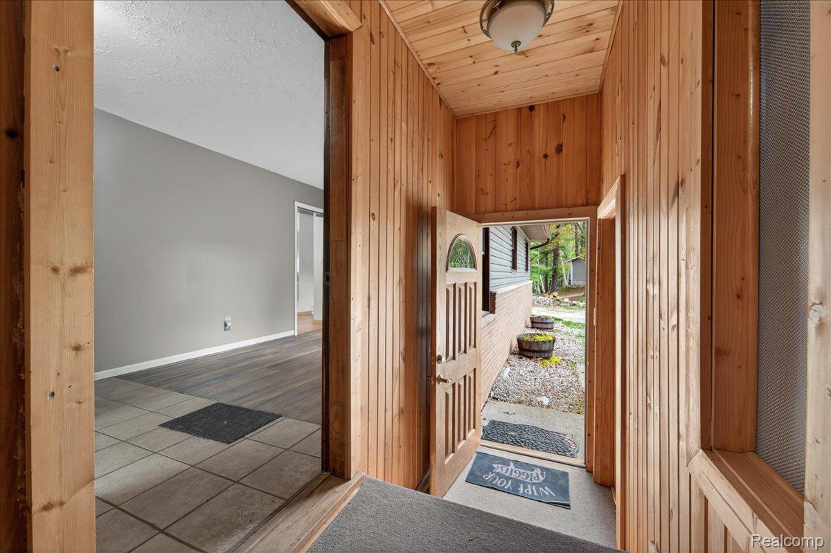 4049 Slattery Road North Branch, MI 48461 - Photo 6 of 45 Foyer entrance featuring wood walls and light tile patterned floors