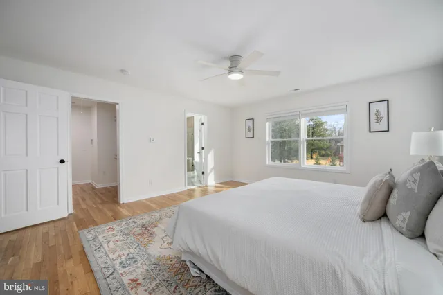 a bedroom with a large bed and wooden floor