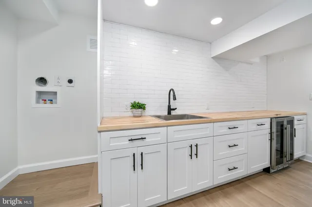 an empty room with wooden floor and a view of living room
