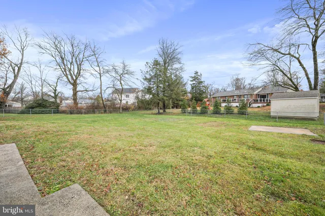 a view of a big house with a big yard and large trees