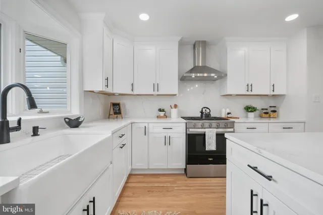 a kitchen with white cabinets stainless steel appliances and sink