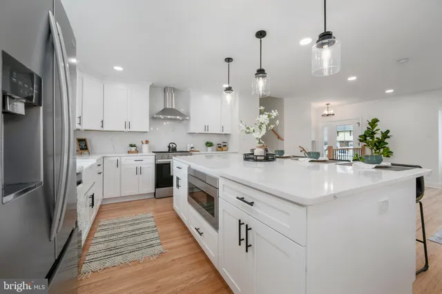 a kitchen with kitchen island a sink stainless steel appliances and cabinets