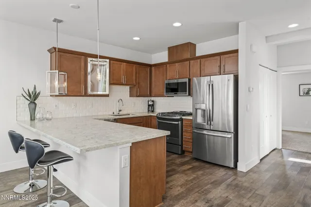 a kitchen with stainless steel appliances granite countertop a sink stove and refrigerator