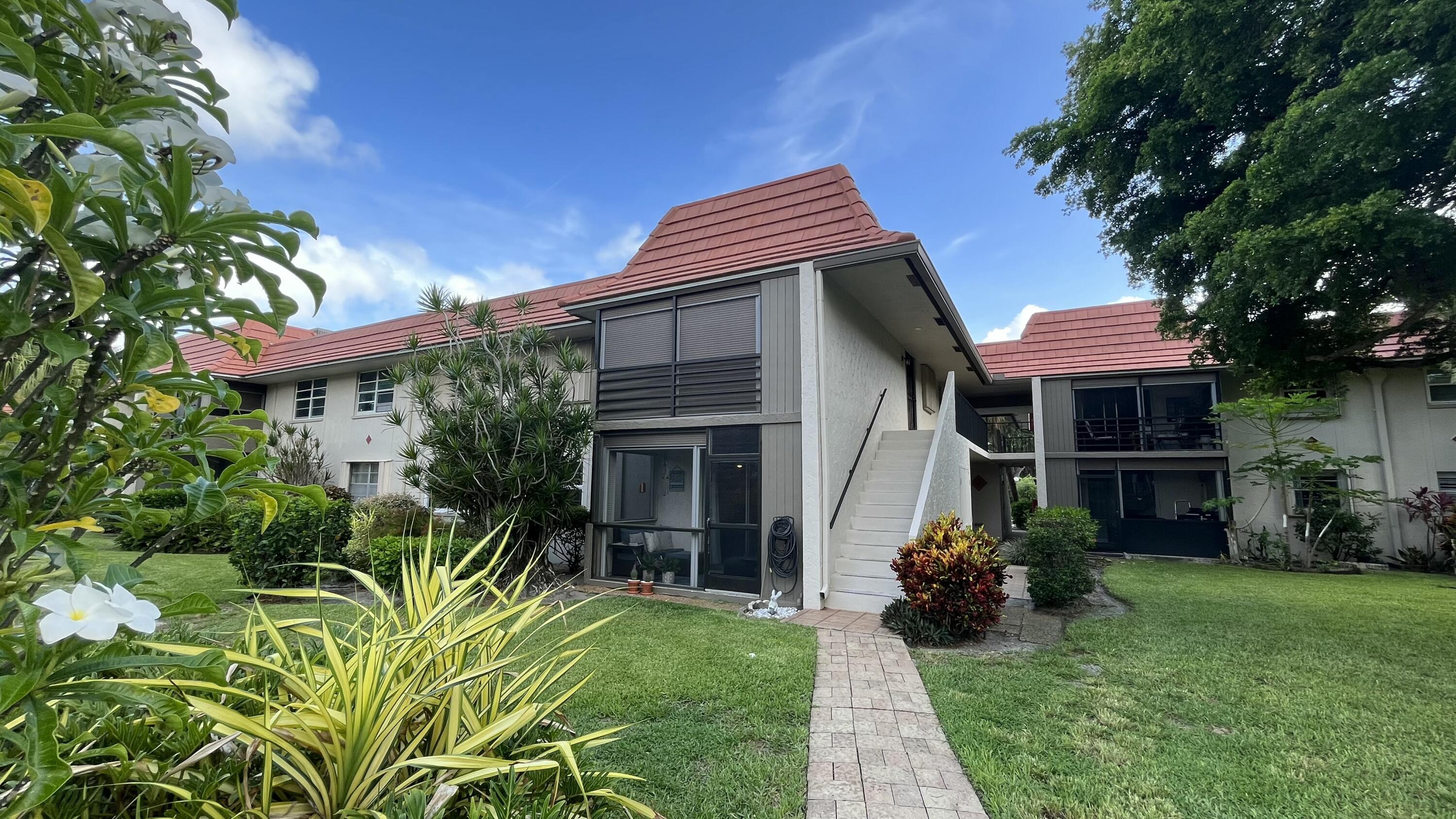 1050 Northwest 13th Street, Unit 193D Boca Raton, FL 33486 - Photo 2 of 55 a front view of a house with a yard