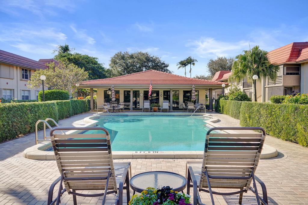 1050 Northwest 13th Street, Unit 193D Boca Raton, FL 33486 - Photo 39 of 55 a view of a patio with table and chairs with wooden floor and fence