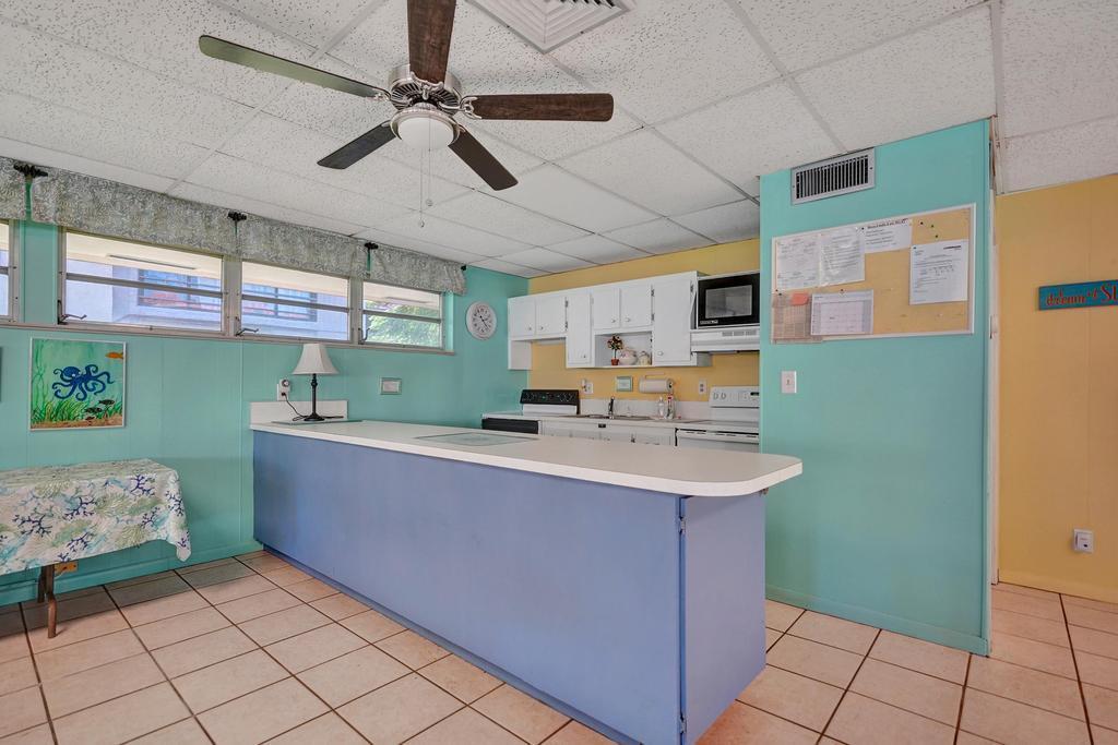1050 Northwest 13th Street, Unit 193D Boca Raton, FL 33486 - Photo 43 of 55 a room with kitchen island a sink and a mirror