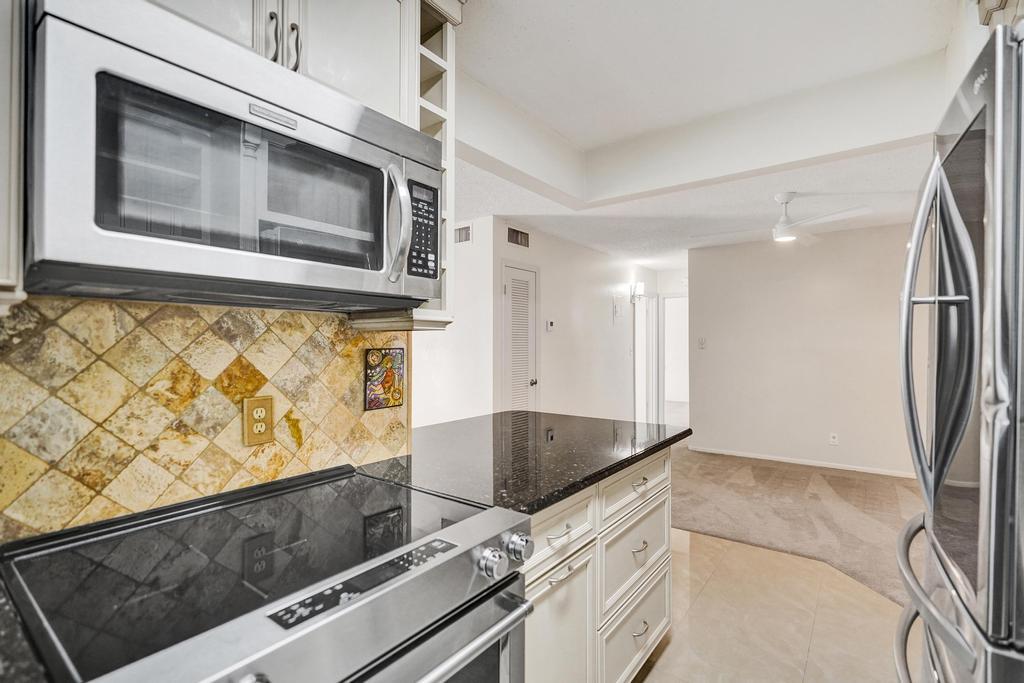 1050 Northwest 13th Street, Unit 193D Boca Raton, FL 33486 - Photo 6 of 55 a kitchen with granite countertop a stove and a microwave