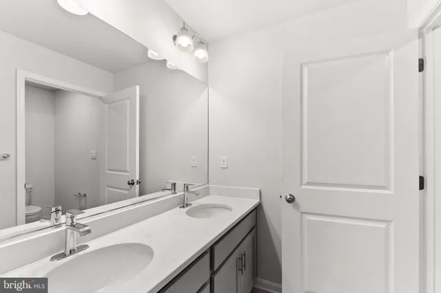 a bathroom with a double vanity sink and a mirror