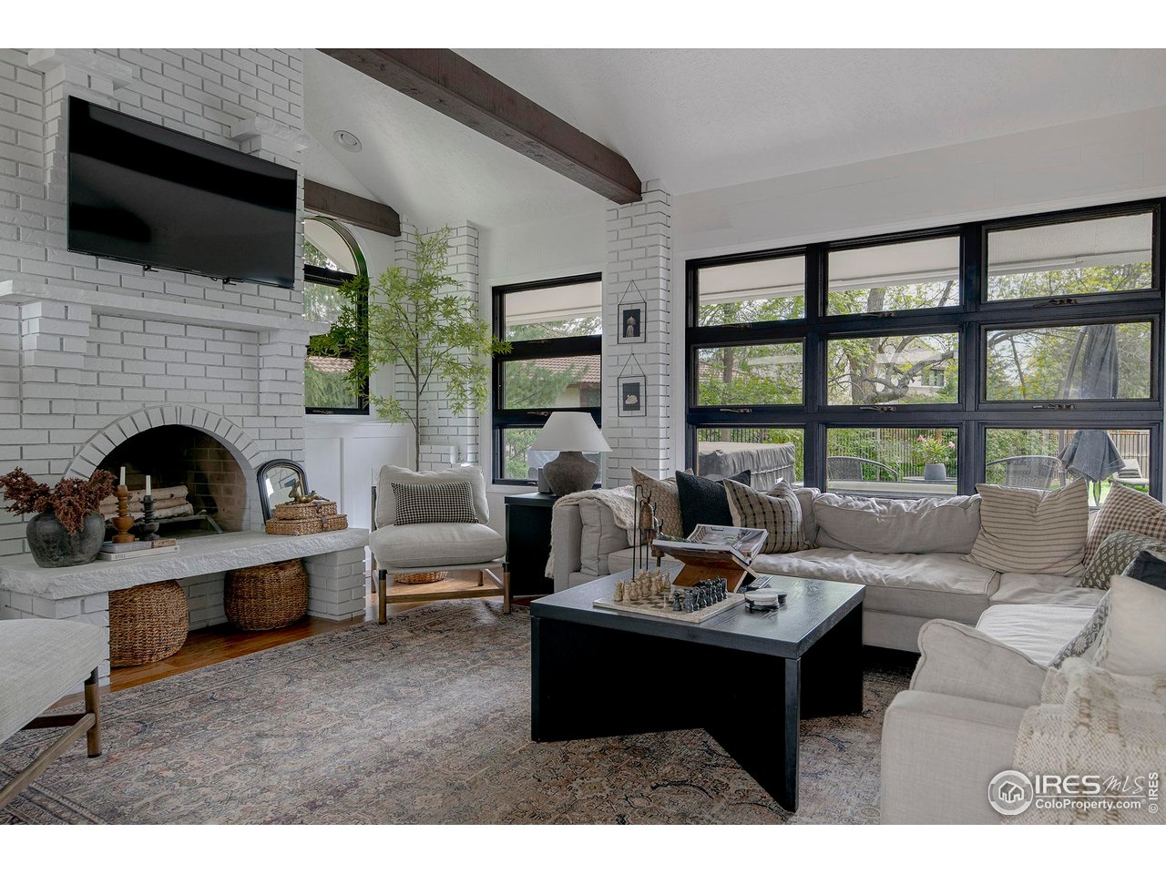 7204 Rustic Trail Boulder, CO 80301 - Photo 14 of 40 The family room has an arched fireplace and a wood burning stove plus two walls of windows that overlook the outdoor areas