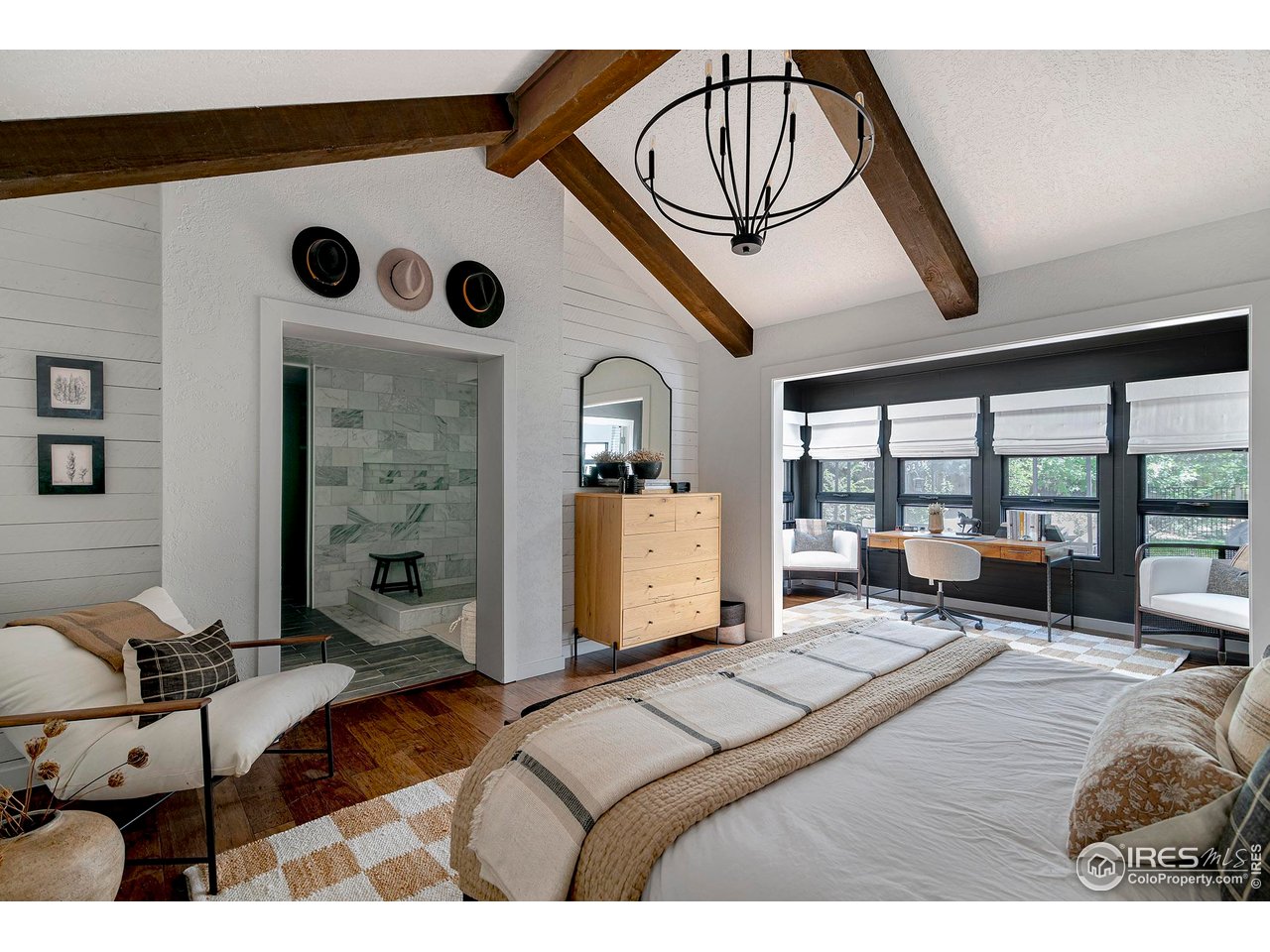 7204 Rustic Trail Boulder, CO 80301 - Photo 24 of 40 The primary bedroom is a peaceful retreat with its vaulted ceilings, wood beams, and hardwood floors. In the distance is the sitting area