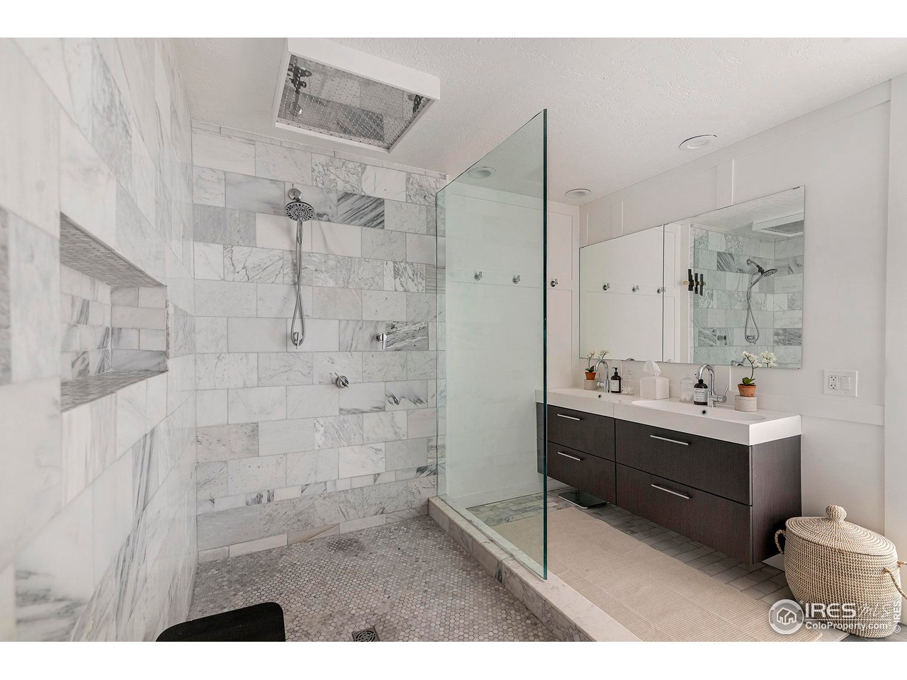 7204 Rustic Trail Boulder, CO 80301 - Photo 27 of 40 The primary bathroom has marble walls and a large shower with rain head plus a stacked washer and dryer in the walk-in closet