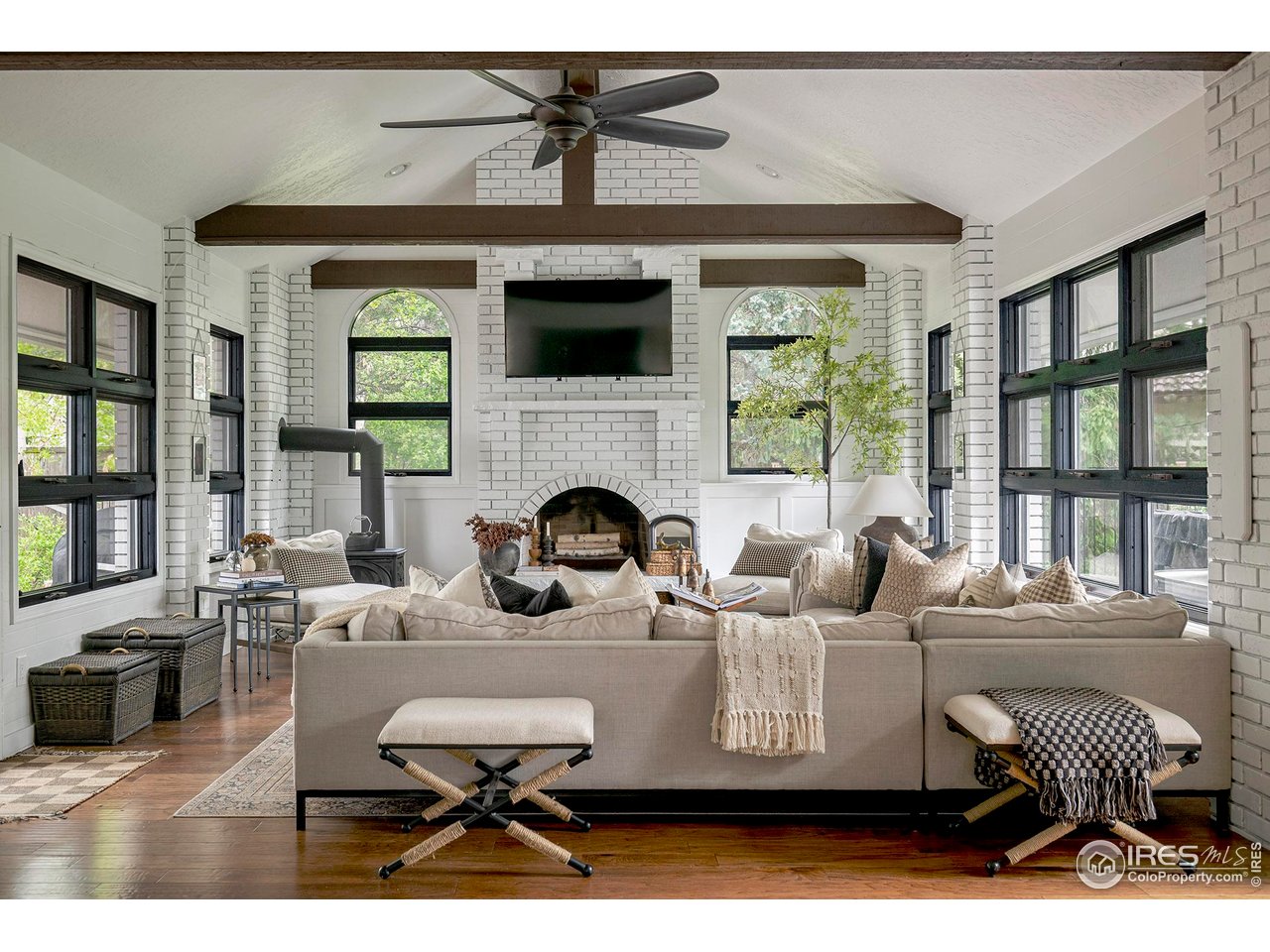 7204 Rustic Trail Boulder, CO 80301 - Photo 3 of 40 The family room has an arched fireplace and a wood burning stove plus two walls of windows that overlook the outdoor areas