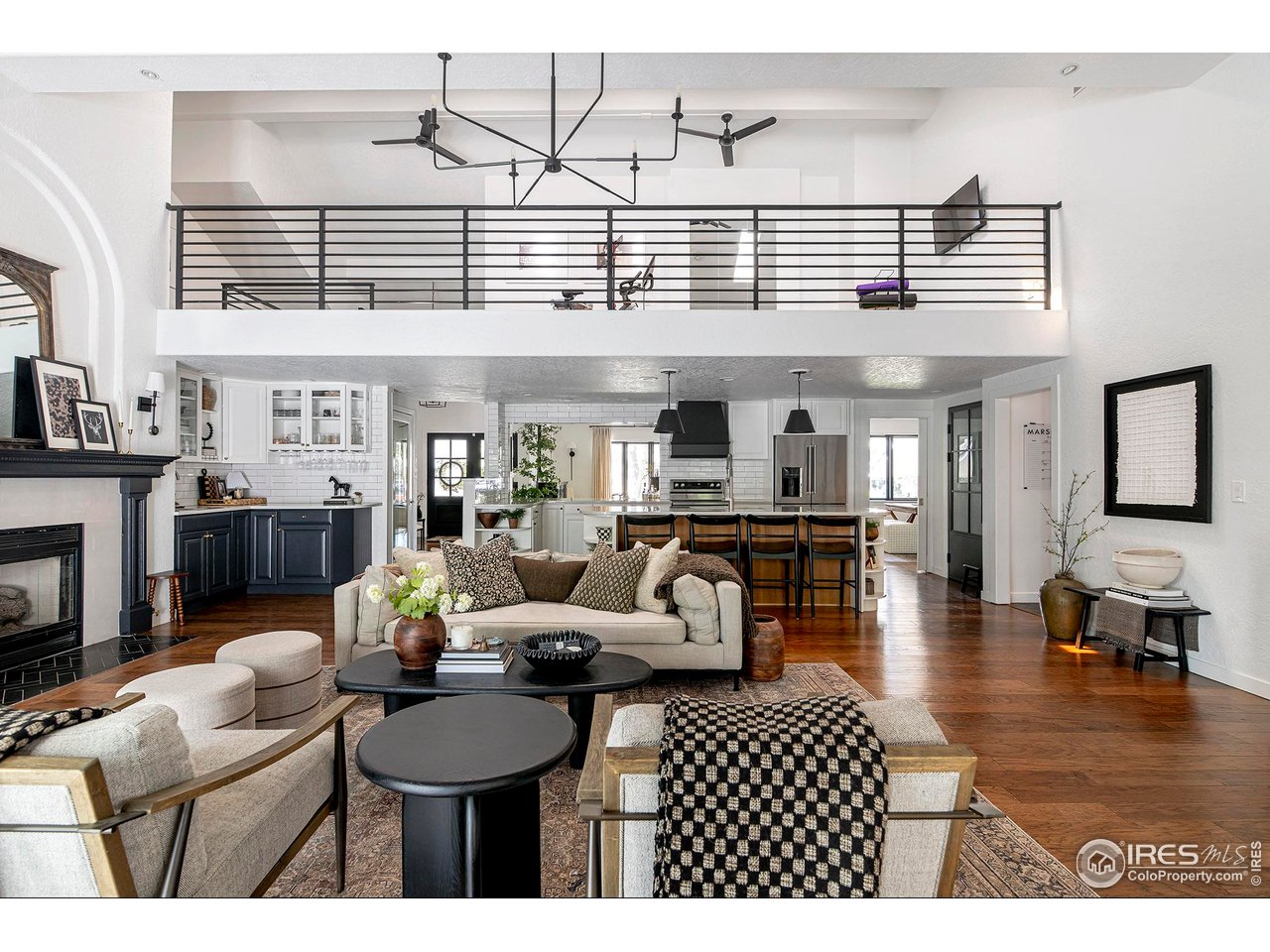 7204 Rustic Trail Boulder, CO 80301 - Photo 8 of 40 Spacious main level living room with hardwood floors, arched fireplace and view to the loft/flex space