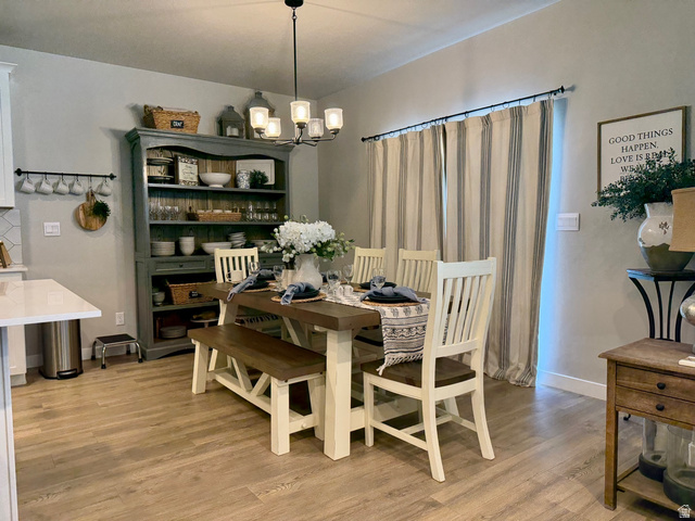 315 South Sherman Street Mapleton, UT 84664 - Photo 11 of 30 Open-concept dining area featuring wood-finish flooring, a contemporary chandelier, and a built-in display hutch