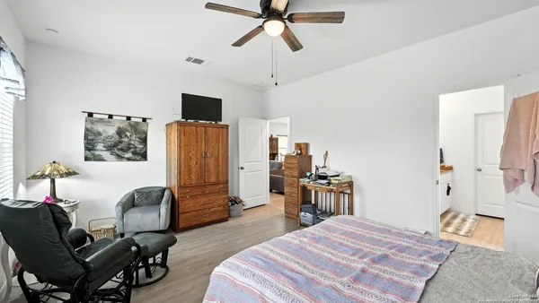 a bedroom with a bed a flat screen tv and a couch