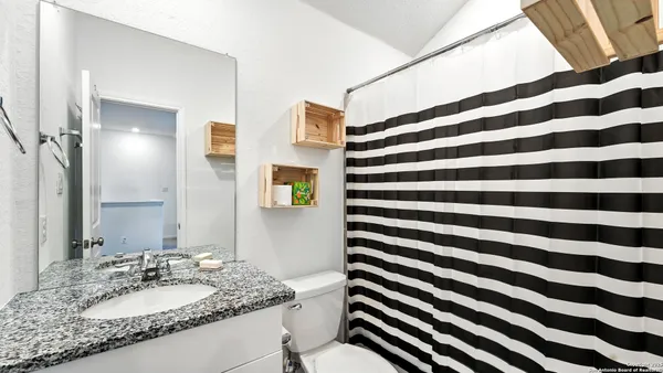 a bathroom with a granite countertop sink and a mirror