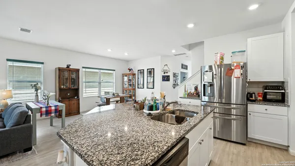 a kitchen with stainless steel appliances granite countertop a refrigerator sink and stove