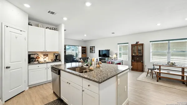 a kitchen with kitchen island granite countertop a sink appliances and cabinets